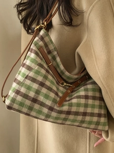 Winter checkered tote bag in green and brown wool fabric with leather straps on a model