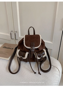 Detail of retro suede backpack with plush fleece trim and front buckle pockets