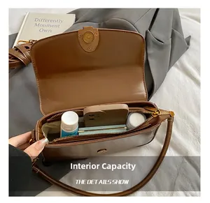 Interior view of brown leather shoulder bag showing capacity for phone and cosmetics