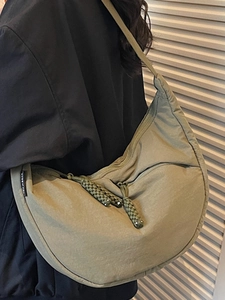 Olive green hobo crossbody bag with woven zipper detail and wide strap for casual style