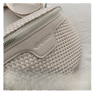 Détail du sac bandoulière tissé avec fermeture éclair argentée et embossage cuir