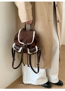 Side view of brown faux suede mini backpack with plush fleece trim and retro buckles