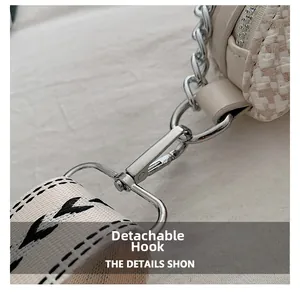 Détail du crochet amovible argenté avec bandoulière tissée sur sac blanc crème