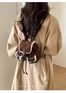 Detailed view of dark brown plush velvet backpack with white faux shearling trim accents