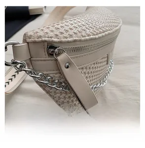 Détail du sac bandoulière en tissu tressé avec fermeture éclair argentée et sangle texturée