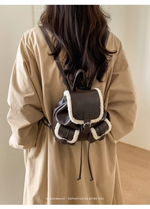 Close-up of retro brown plush mini backpack with fleece trim and magnetic closure detail