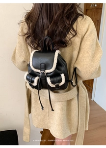 Close-up of a mini leather backpack with plush sheepskin trim and retro buckle details