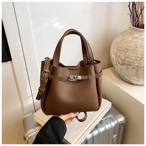 Close-up of brown lychee grain leather bucket bag with silver metal twist lock closure