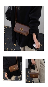 Detail of vintage brown leather baguette bag with golden U-shaped metal clasp buckle