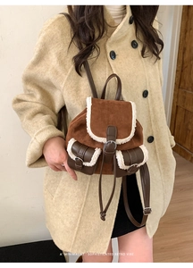 Detail of retro brown suede backpack with white plush faux fur trim and leather straps