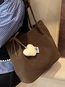 Brown suede tote bag with heart charm and bow accent, vintage minimalist shoulder bag style