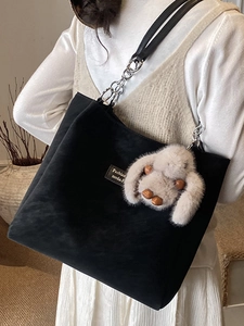 Minimalist black tote bag with plush bunny charm and silver chain strap for winter