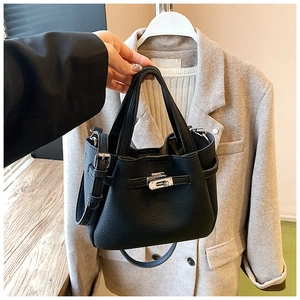 Close-up of black lychee grain leather bucket bag with silver metal swivel lock detail