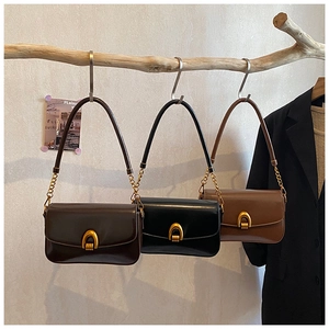 French vintage shoulder bags in brown and black leather with gold arched buckle detail