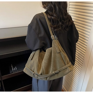 Detail of dark green suede tote bag featuring contrast stitching and slouchy texture