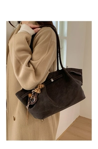 Detail of suede tote bucket bag with metallic buckle and leopard print charm