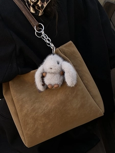 Brown suede tote bag with plush bunny charm and chain straps for minimalist casual style