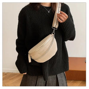 Détail du sac croissant tissé crème avec bandoulière géométrique et chaîne argent