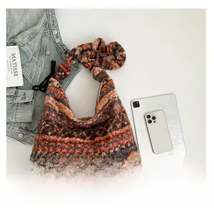 Detailansicht der bunten Kunstpelz-Hobo-Tasche mit Metall-Logo und breitem Schultergurt