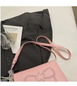 Pink square bag detail featuring rivet bow pattern and elegant pearl lace pendant
