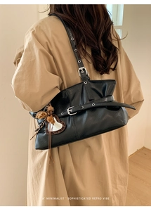 Détail d'un sac sous le bras en cuir noir avec boucle et breloque cœur léopard chic