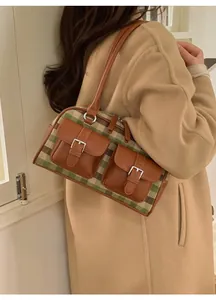Detail view of retro plaid shoulder bag with double pockets worn with a khaki wool coat