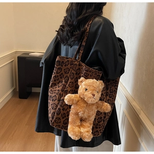 Dettaglio della borsa tote leopardata con ciondolo a orsetto portata sulla spalla