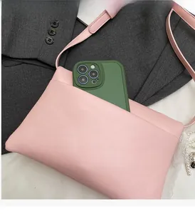 Close-up of pink synthetic leather shoulder bag showing front pocket capacity for smartphone