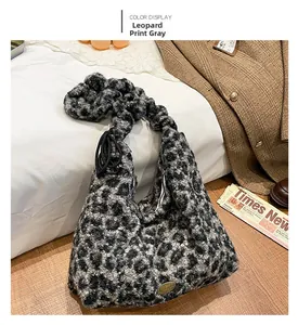 Detail der grauen Kunstfelltasche mit Leopardenmuster und Handmade-Metallschild