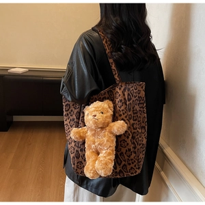 Dettaglio borsa tote leopardata con ciondolo a forma di orsetto bruno a tracolla
