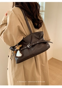 Détail du sac à bandoulière en cuir marron foncé avec boucle et breloque miroir cœur