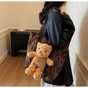 Vista laterale dettagliata della borsa tote paisley marrone con orsetto 3D