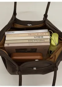 Internal view of dark brown suede tote bag showing large capacity for books and umbrella