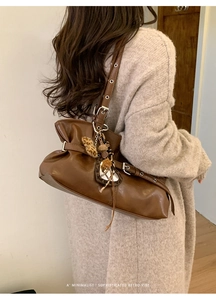 Sac sous le bras plissé marron rétro avec breloque cœur léopard sur un cardigan beige