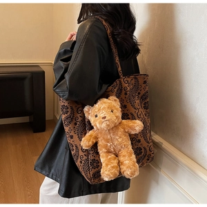 Dettaglio della borsa tote con stampa paisley e ciondolo a forma di orsetto di peluche
