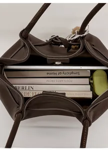 Top view of large brown leather tote bag showing spacious interior with tablet and books