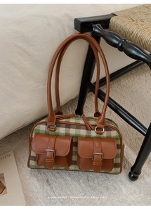 Close-up of retro tweed fabric texture and leather buckle pockets on large tote bag