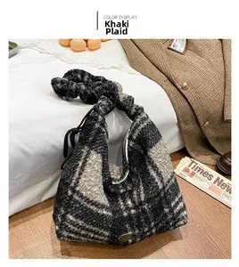 Detailansicht der khakifarbenen Plüschtasche mit Knotengriff und metallischem Logo