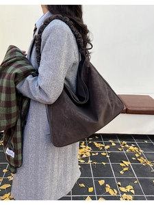 Detail view of dark brown frosted tote bag with pleated cloud shoulder strap for women