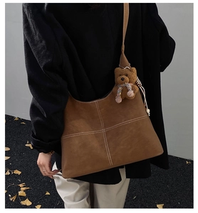 French vintage brown hobo bag with white stitching detail and plush bear charm