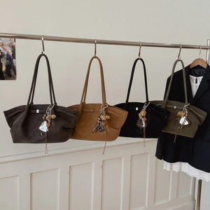 Minimalist suede tote bags in four colors hanging on a rack for fashion display