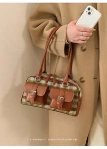Detail of retro plaid Boston bag with leather pockets and silver buckle accents