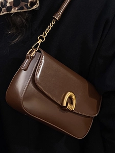 Elegant brown leather crossbody bag with golden hardware and chain strap for women