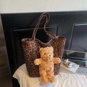 Dettaglio della borsa tote leopardata con ciondolo a forma di orsetto di peluche in rilievo