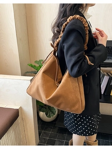 Detail of caramel brown suede tote bag with stylish ruched shoulder strap and drawstring accents