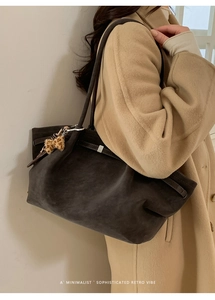Detail of vintage brown suede tote bag with leopard bow and silver buckle accents