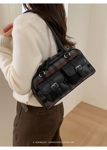 Detail of retro plaid shoulder bag featuring leather pockets with silver metal buckles