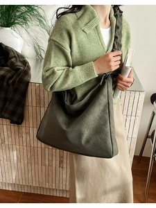 Detail view of large olive green pleated tote bag with matte leather texture for women