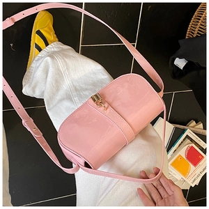Detail of pink patent leather handbag with glossy finish and gold metallic buckle