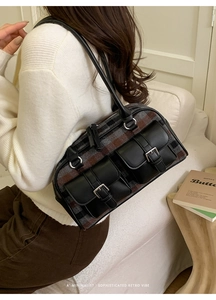 Detail of vintage plaid Boston bag with dual leather front pockets and metal buckles